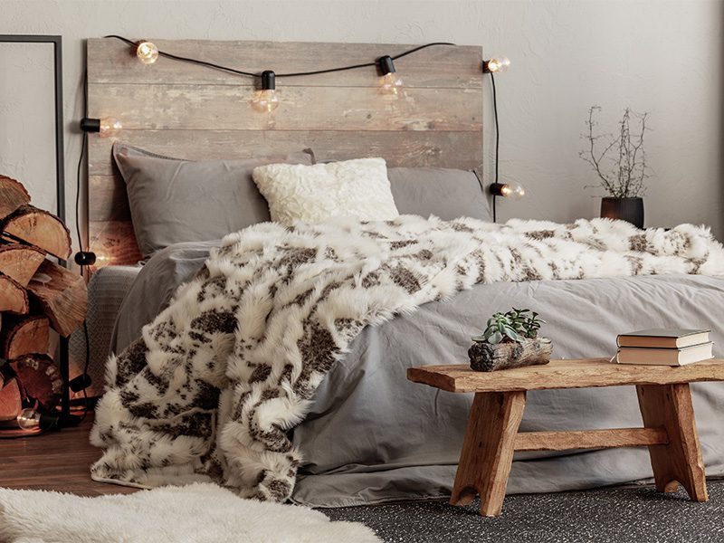 Rustic bedroom with wood headboard and grey bedding