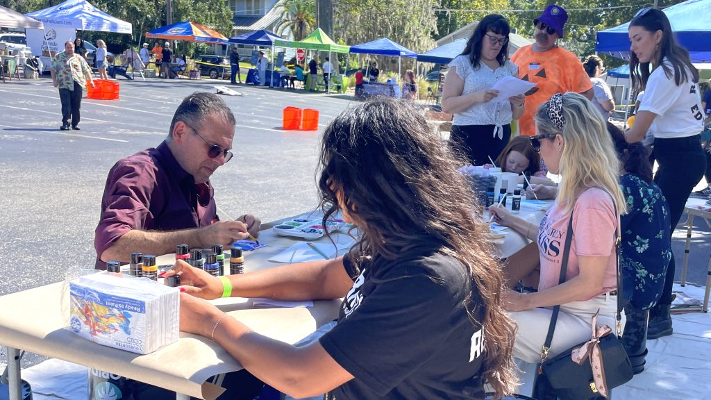 Community members painting together at the Paint a Brighter Day volunteer event in Orlando.